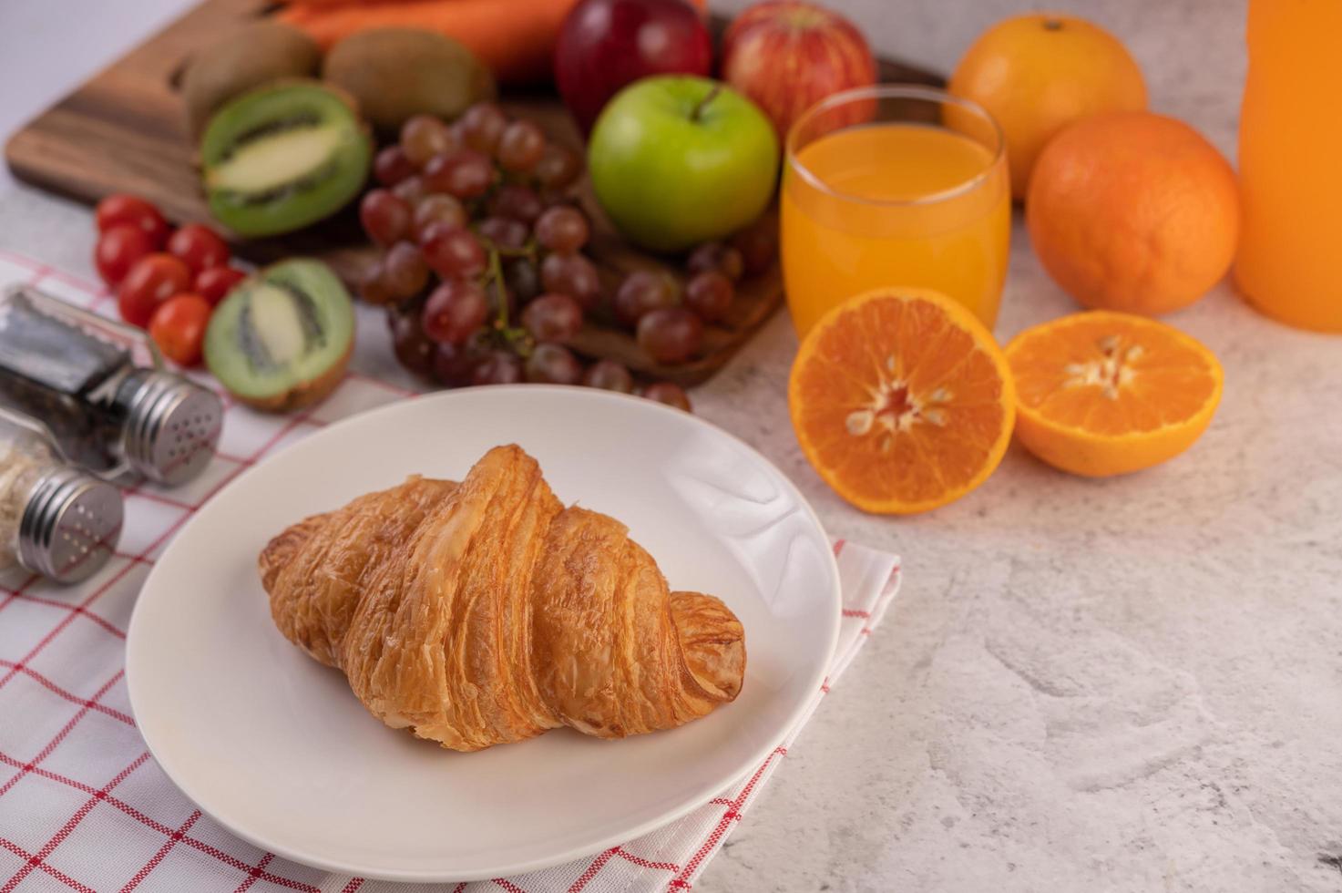 croissant con acompañamientos de frutas para el desayuno foto