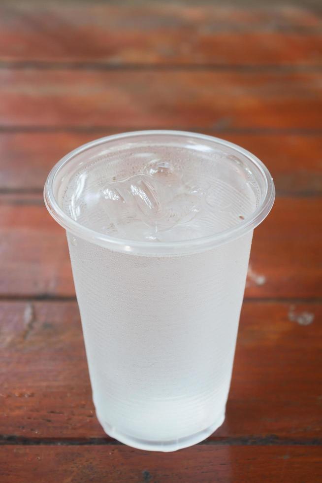 vaso de agua en una mesa de madera foto