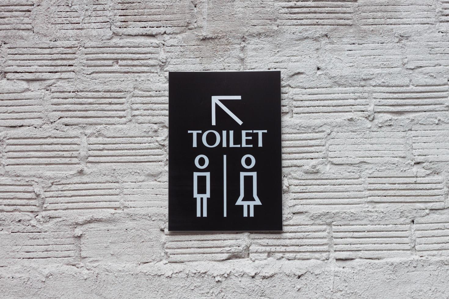 Toilet sign on a white wall photo