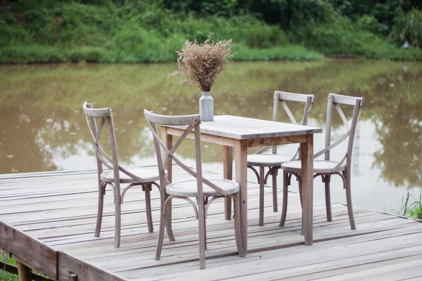 Wooden table and chairs on a dock outside photo