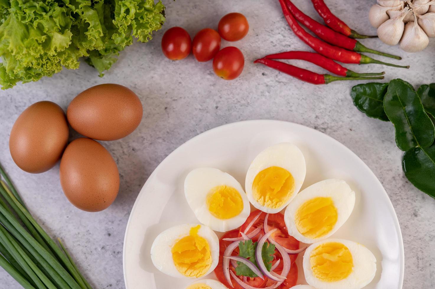 Half boiled eggs with tomatoes and spring onions photo