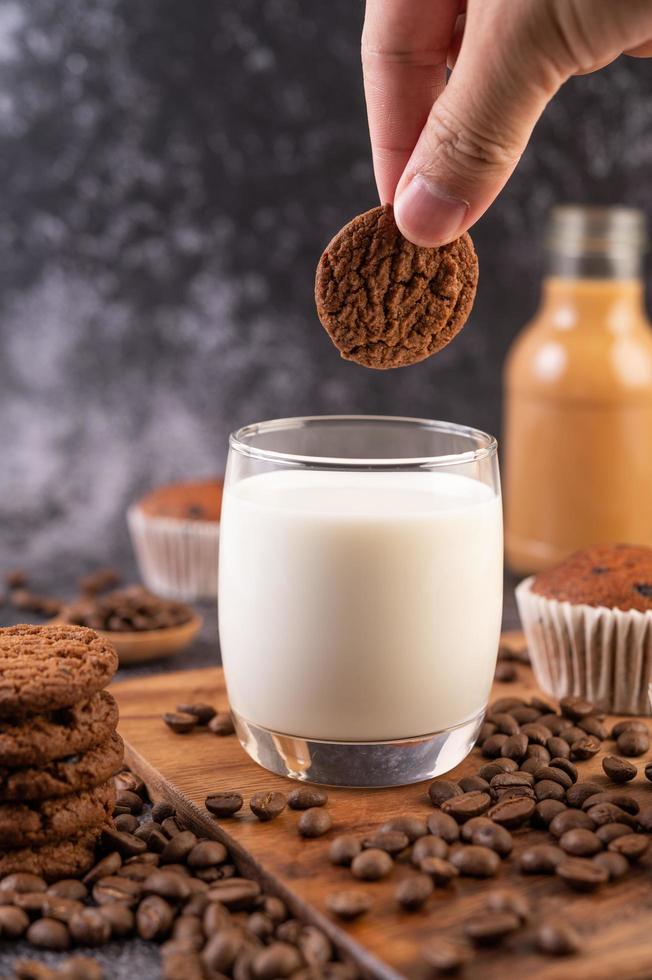 mano mojando una galleta en leche foto