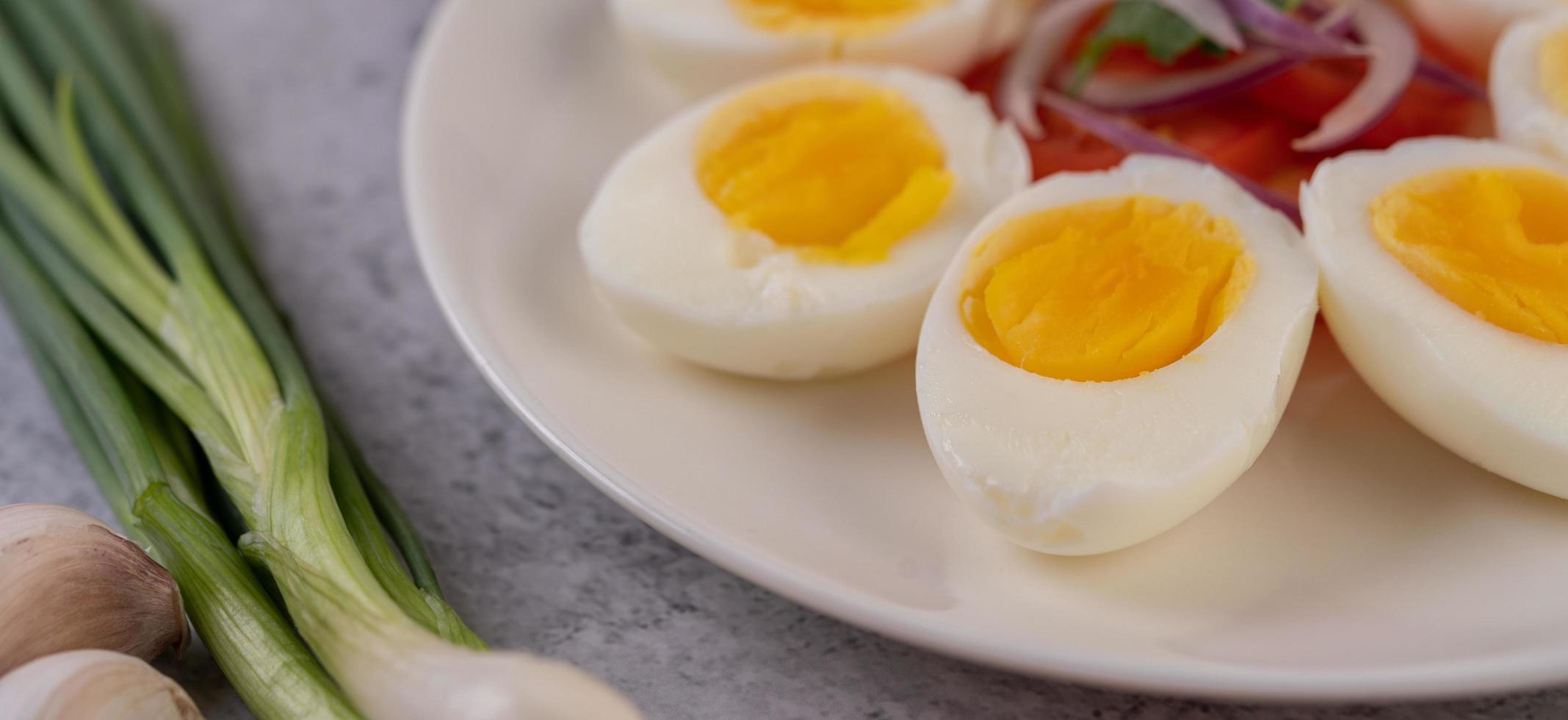 Half boiled eggs with tomatoes and spring onions photo