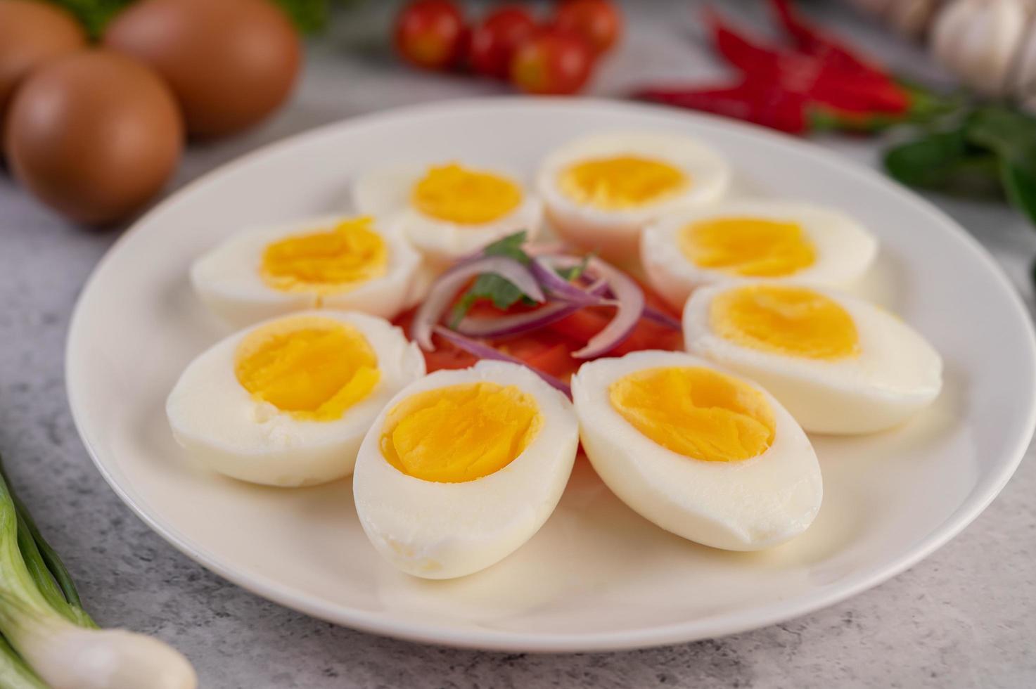 medio huevos cocidos con tomates y cebolletas foto