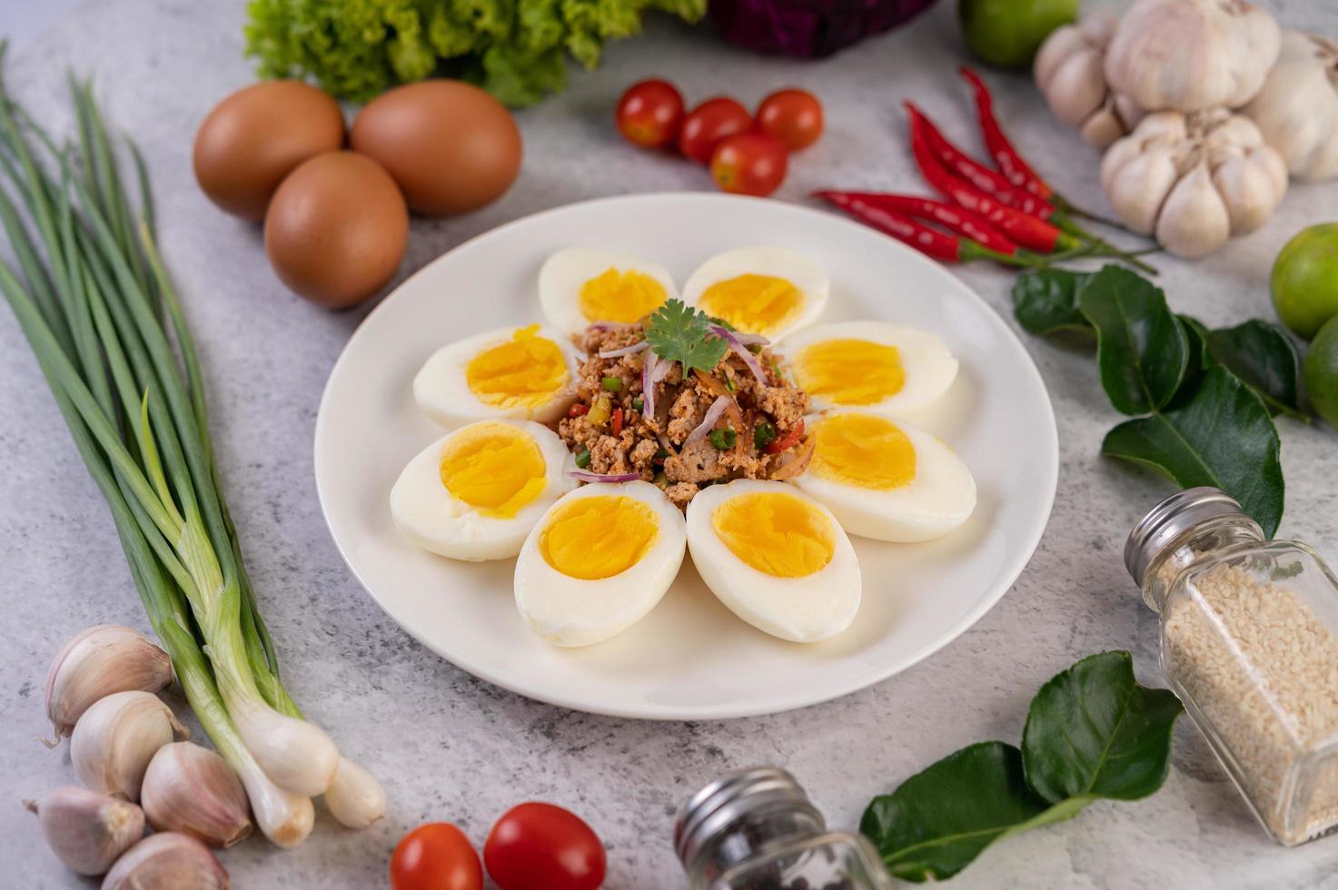 medio huevos cocidos con tomates y cebolletas foto