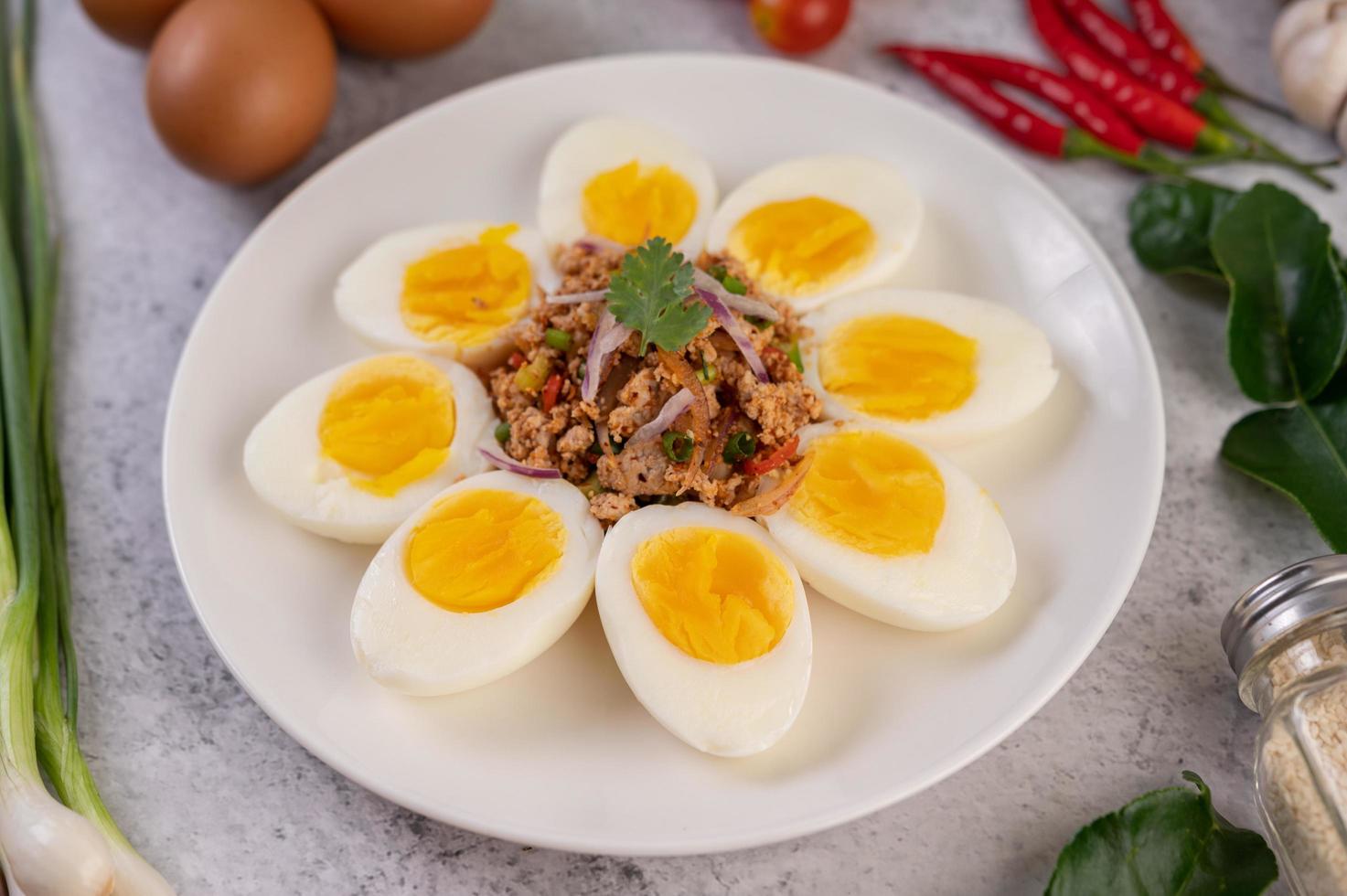 medio huevos cocidos con tomates y cebolletas foto