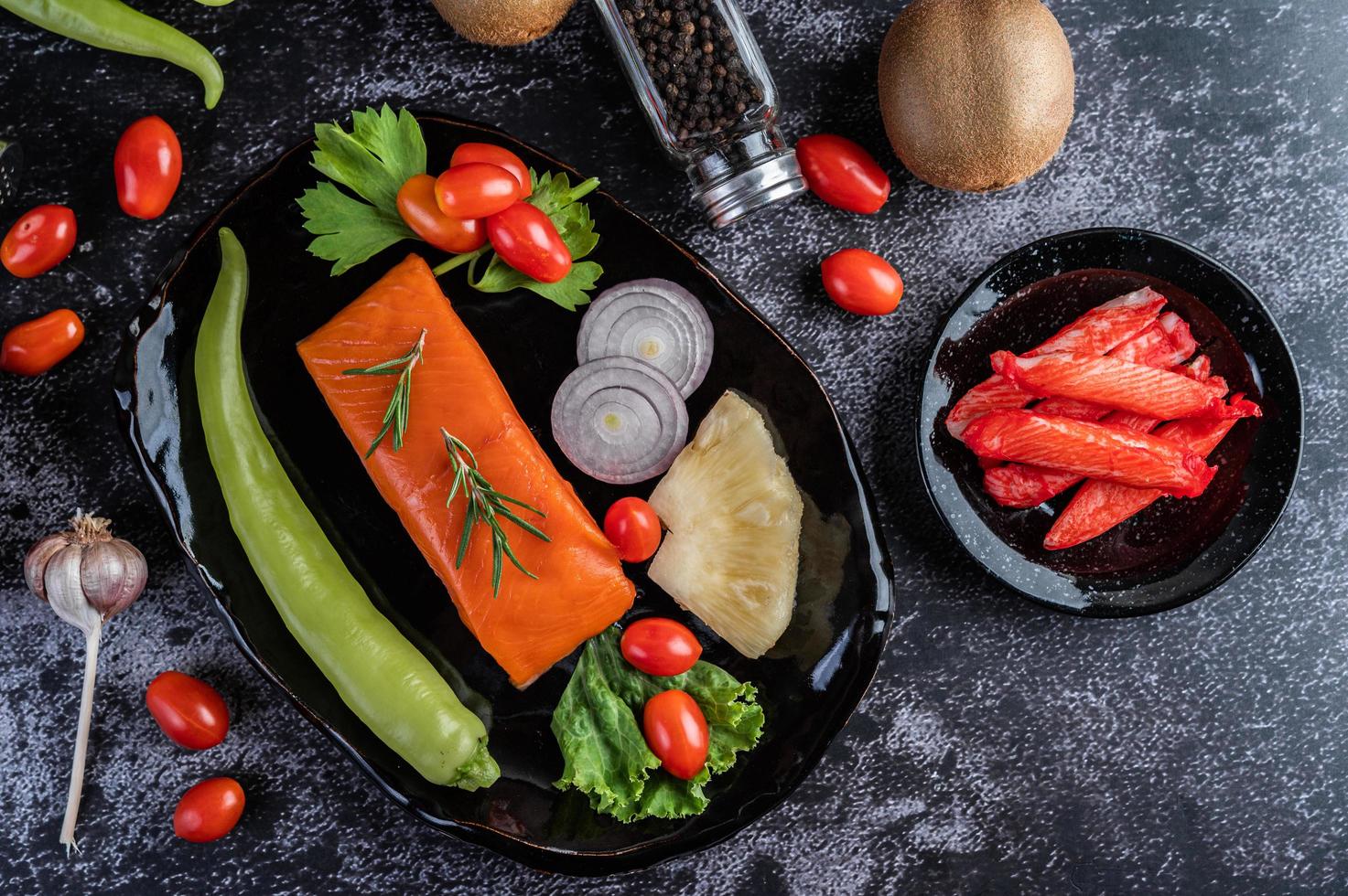 Raw salmon fillet with pepper, kiwi, pineapples, and rosemary photo