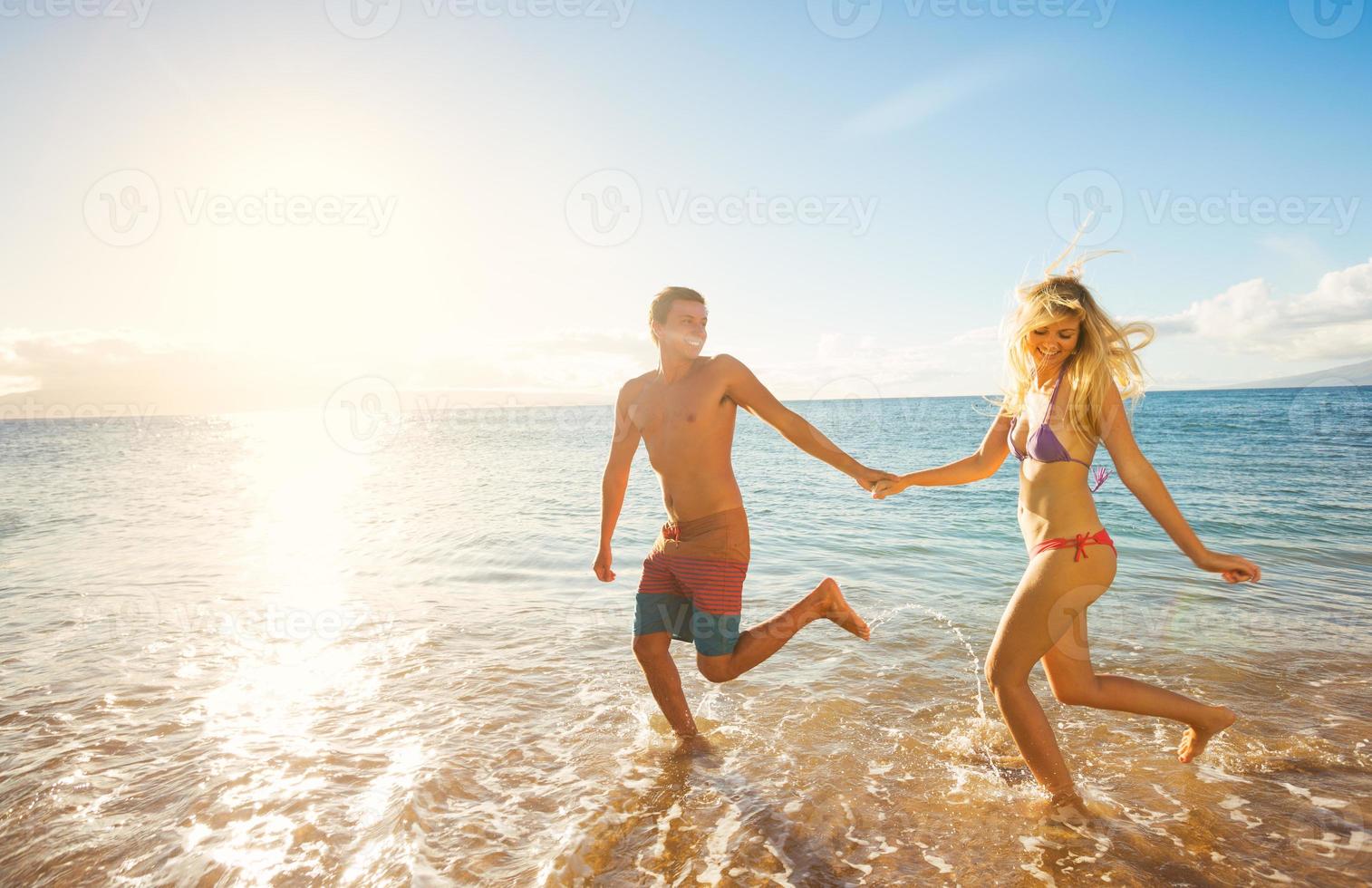 pareja feliz, en, playa tropical, en, ocaso foto