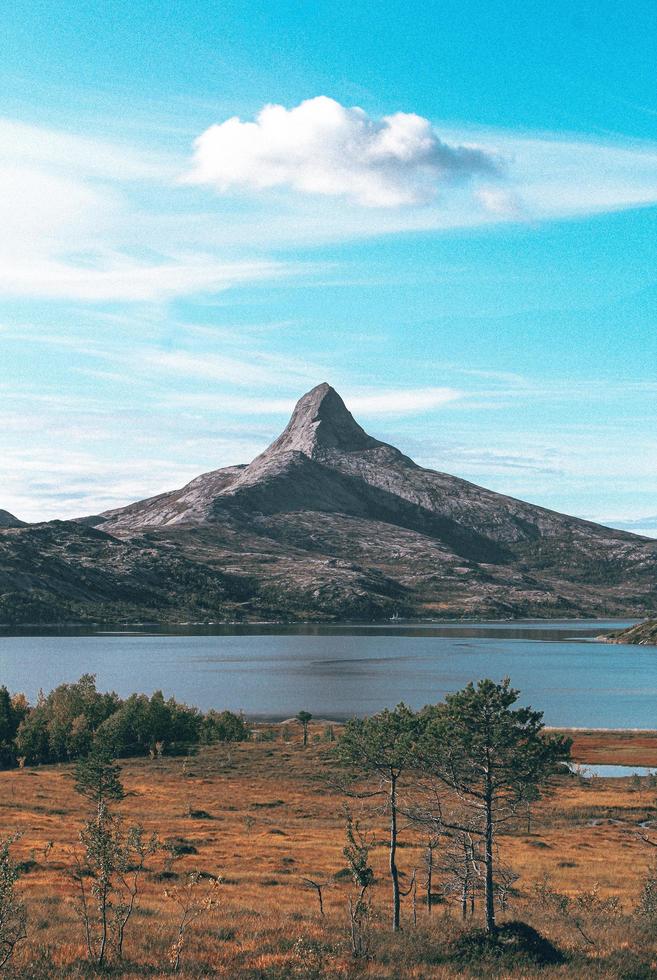 Mountain near a body of water under a blue sky photo