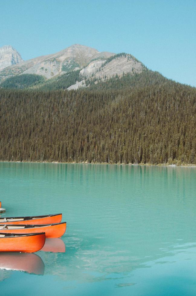 Orange canoes in blue water photo