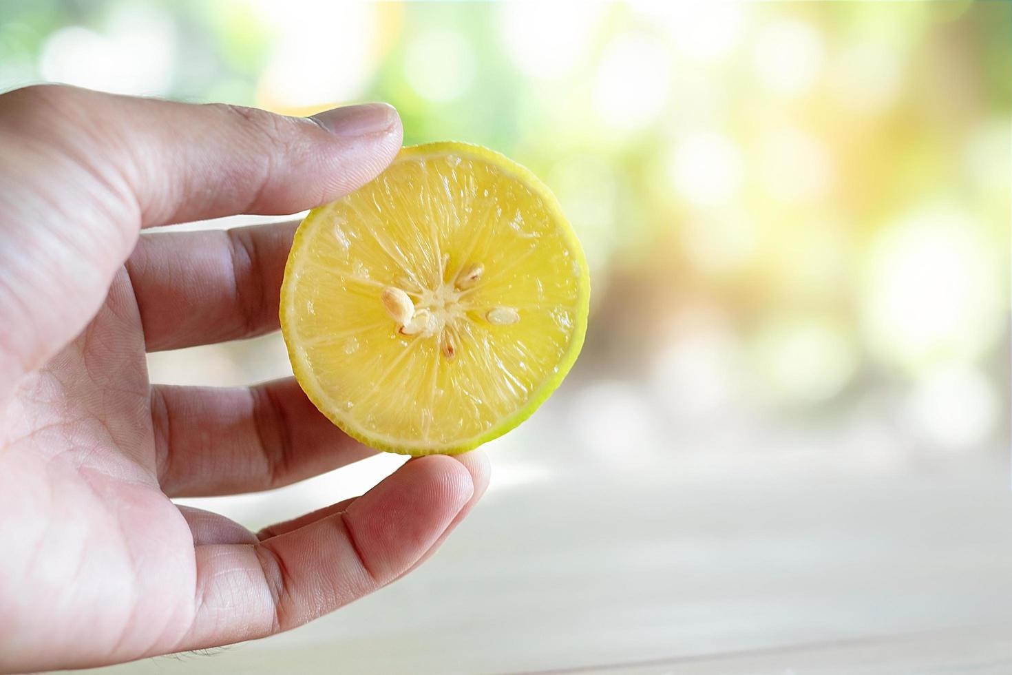 Hand holding a fresh lemon photo