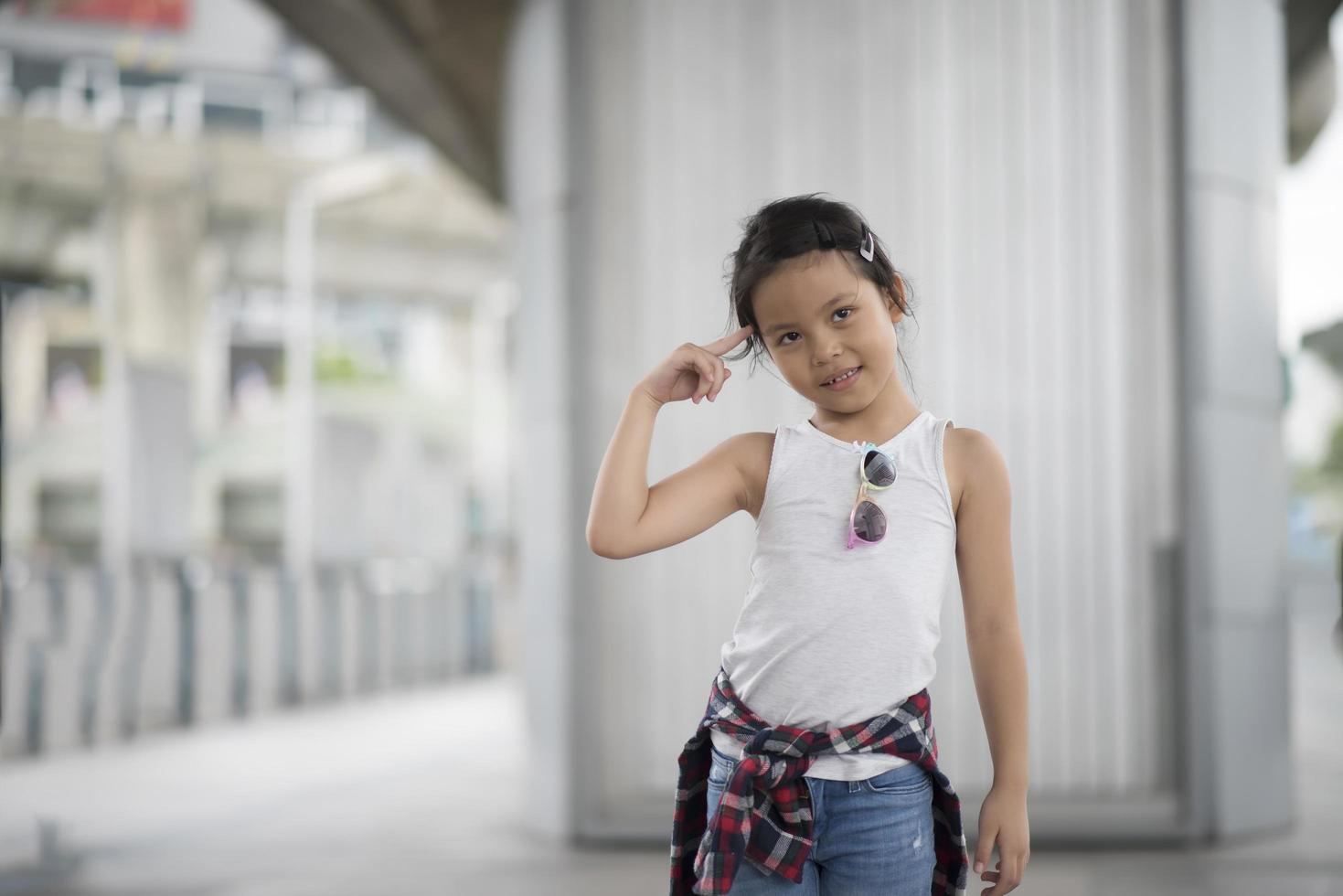 niña inteligente de pie en la ciudad foto