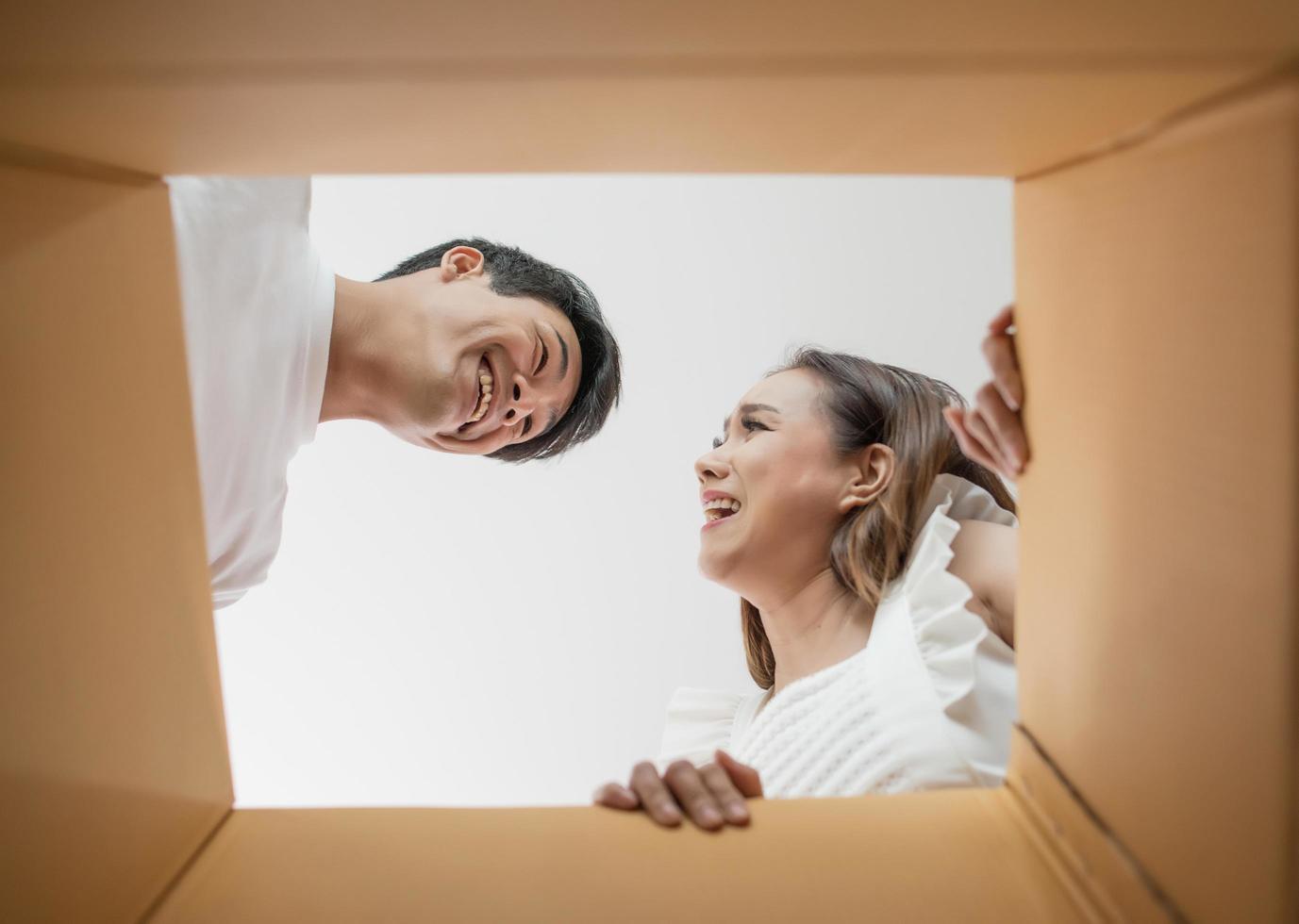 Happy couple opening a box and looking inside photo