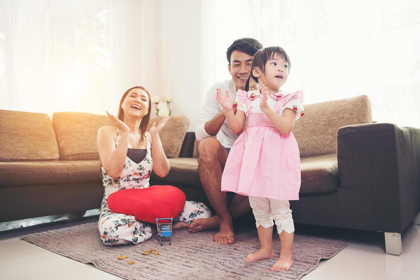 niño con sus padres jugando en el suelo en casa foto