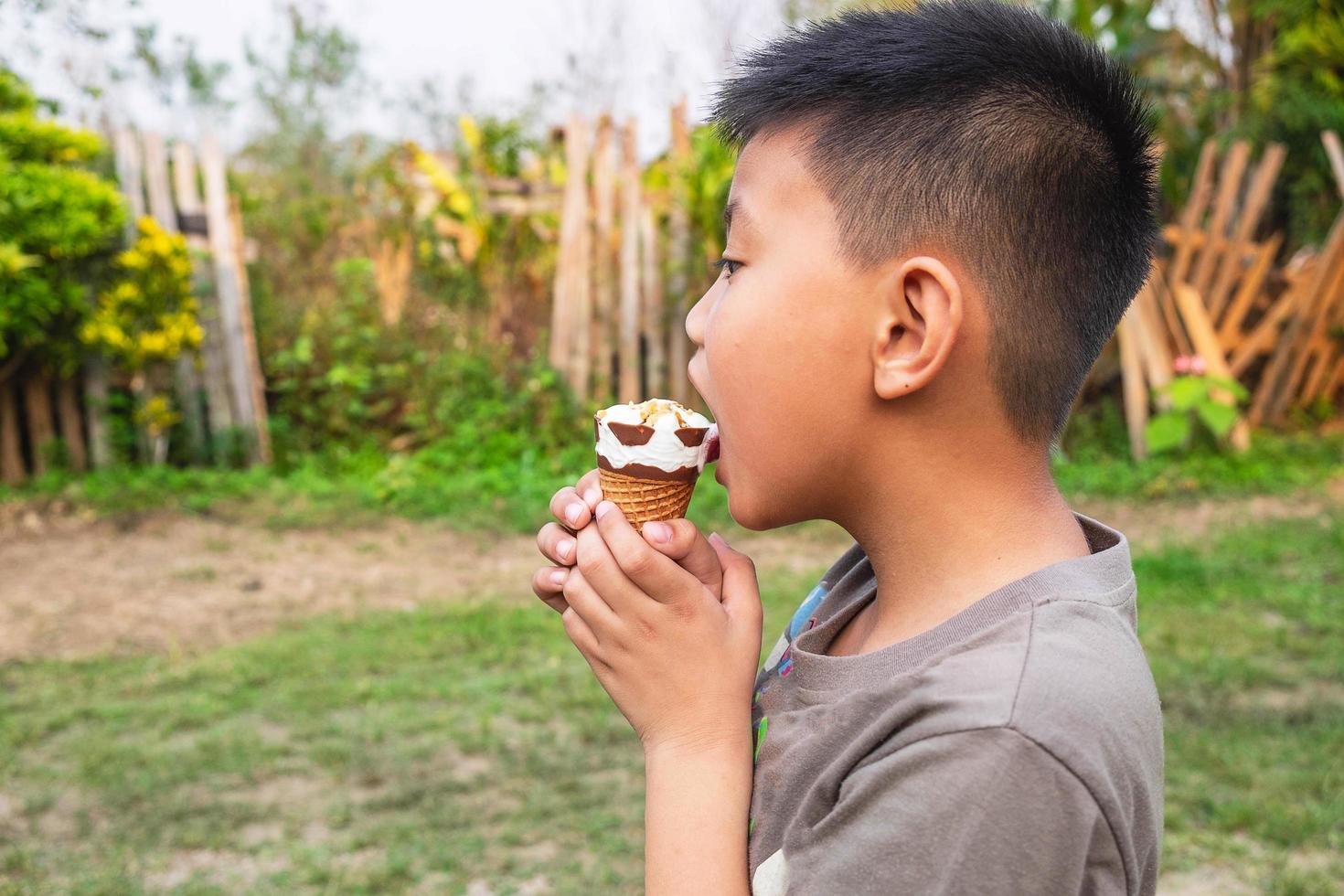 Side profile of a boy eating an ice cream photo