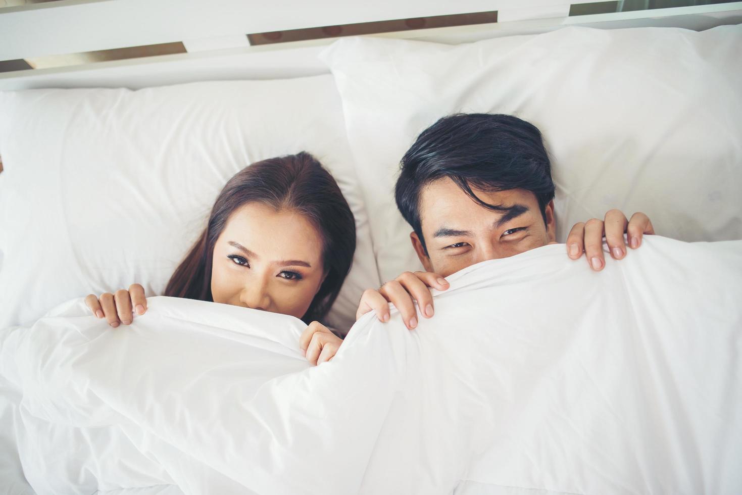 pareja feliz acostado juntos en su cama foto
