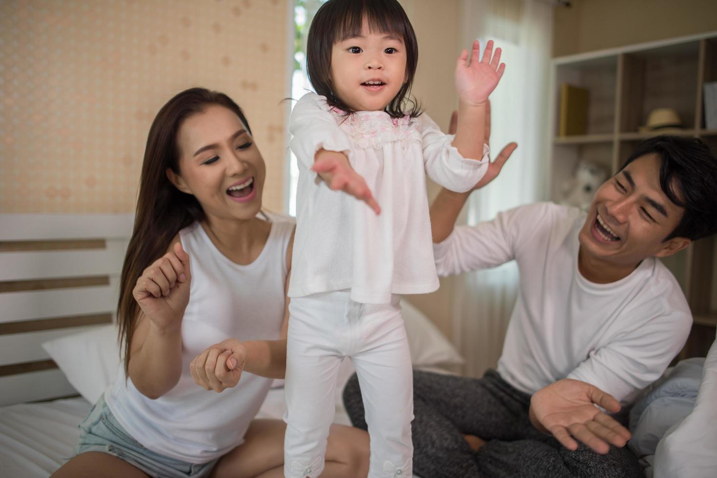 niño feliz con padres jugando foto