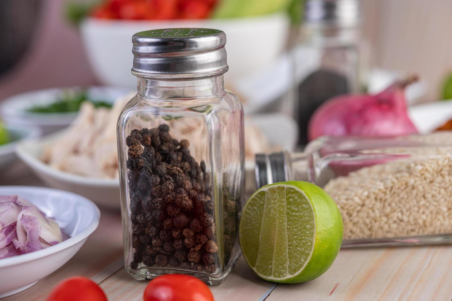Pepper shaker on wooden table with fresh vegetables photo