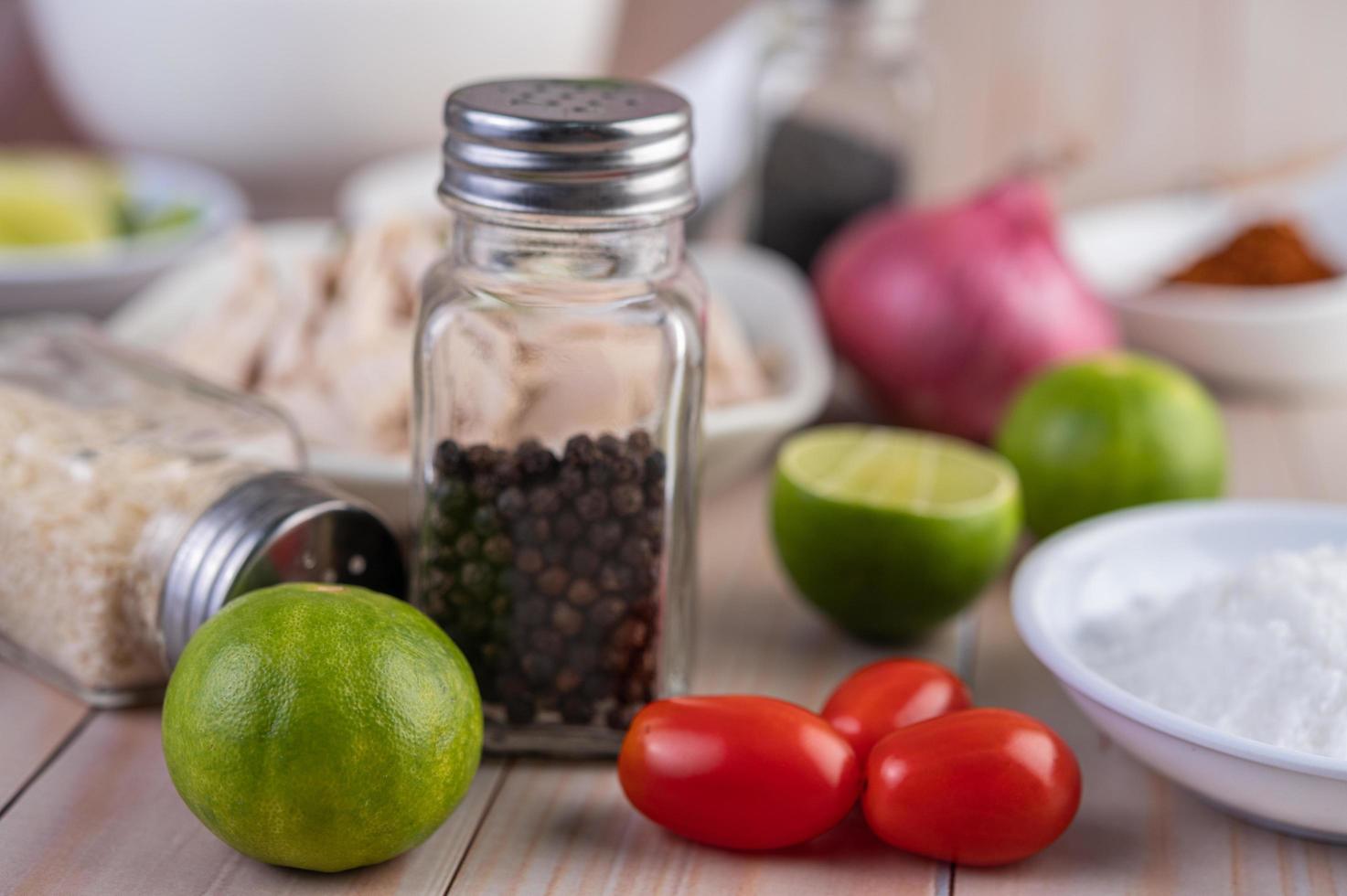 Close-up of limes and tomatoes with pepper on a wooden table photo