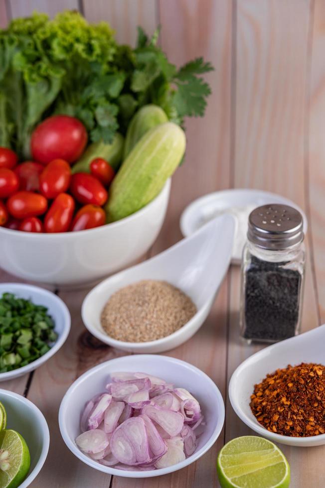 Boiled chicken pieces with vegetables and spices on a wooden table photo