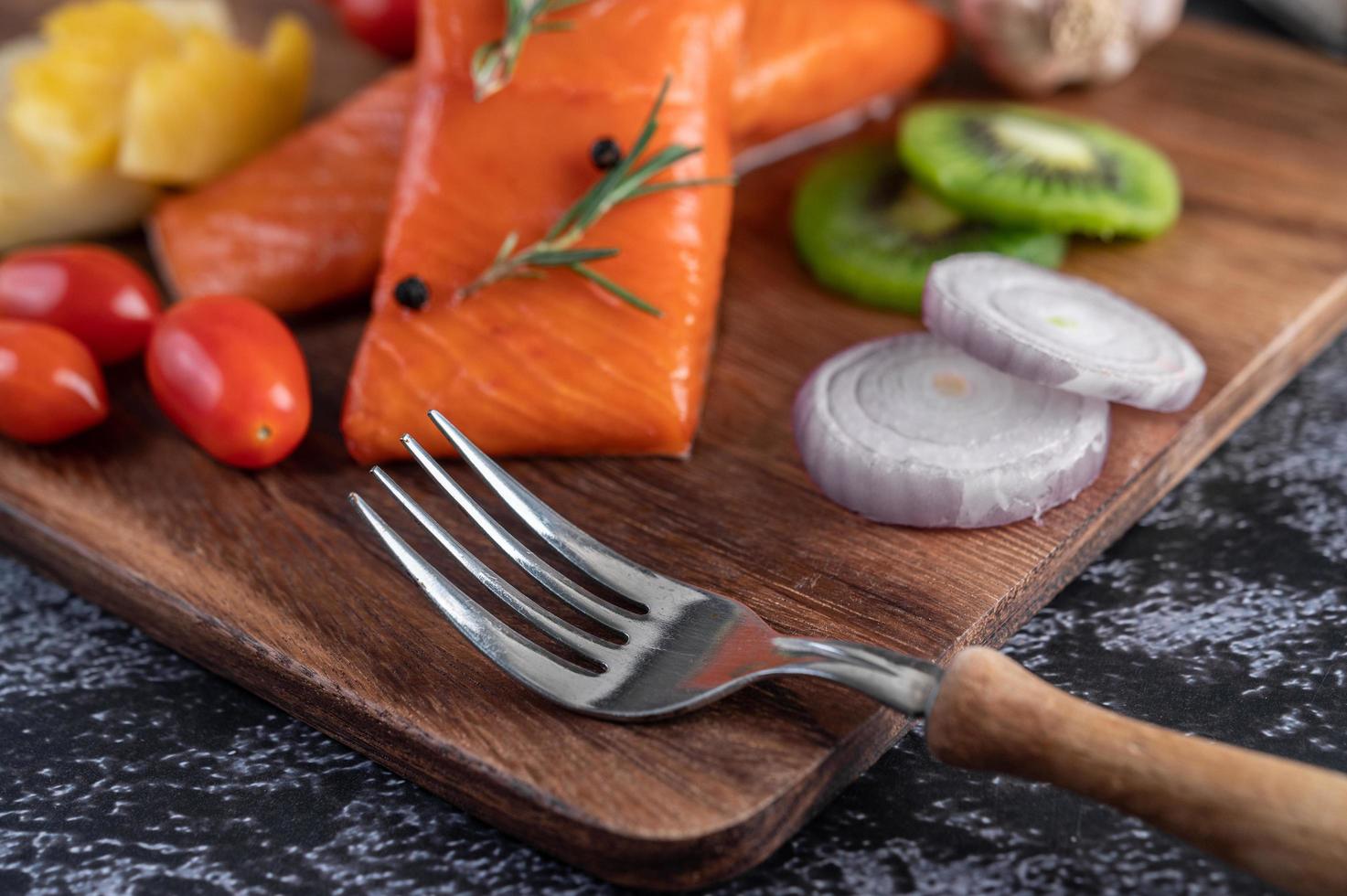 Raw salmon fillets with pepper, kiwi, pineapple and rosemary photo