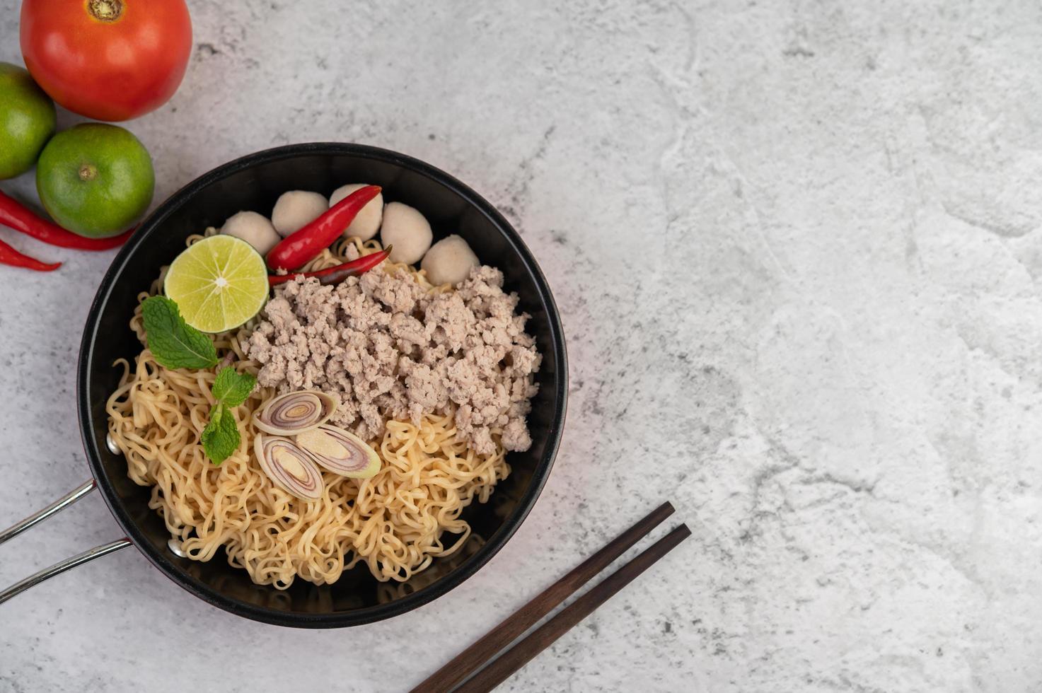 Minced pork in a frying pan with lime, chilies, and meatballs photo