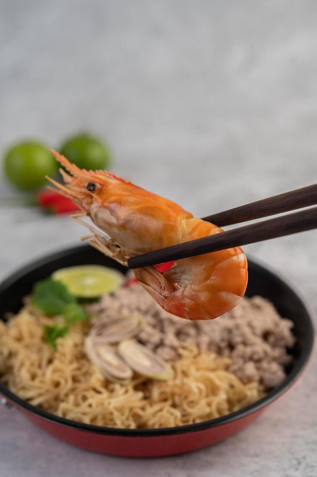 carne de cerdo picada en una sartén con limón, chiles y albóndigas foto