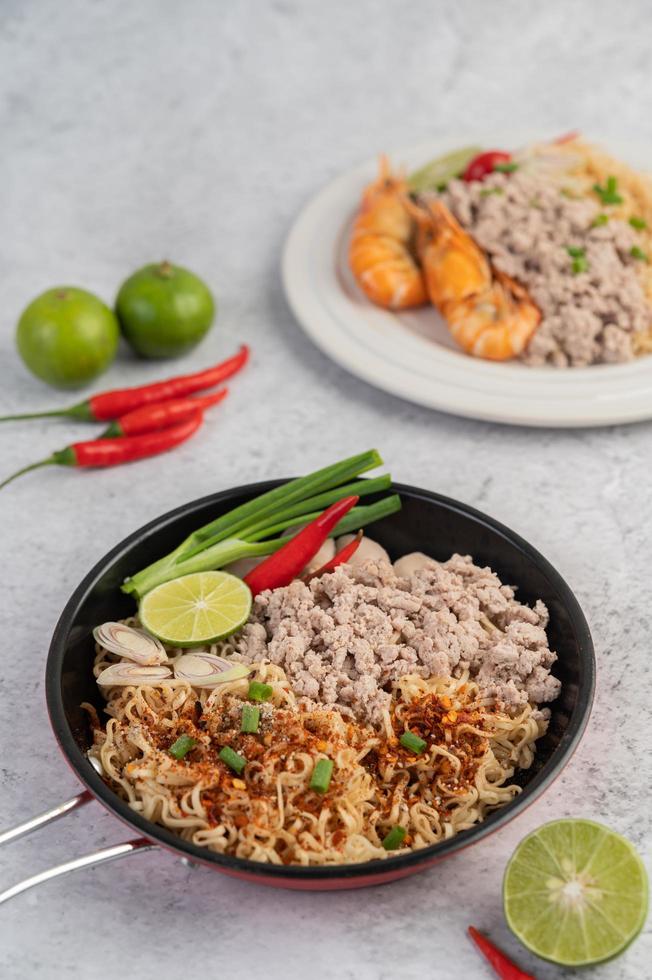 Minced pork in a frying pan with lime, chilies, and meatballs photo