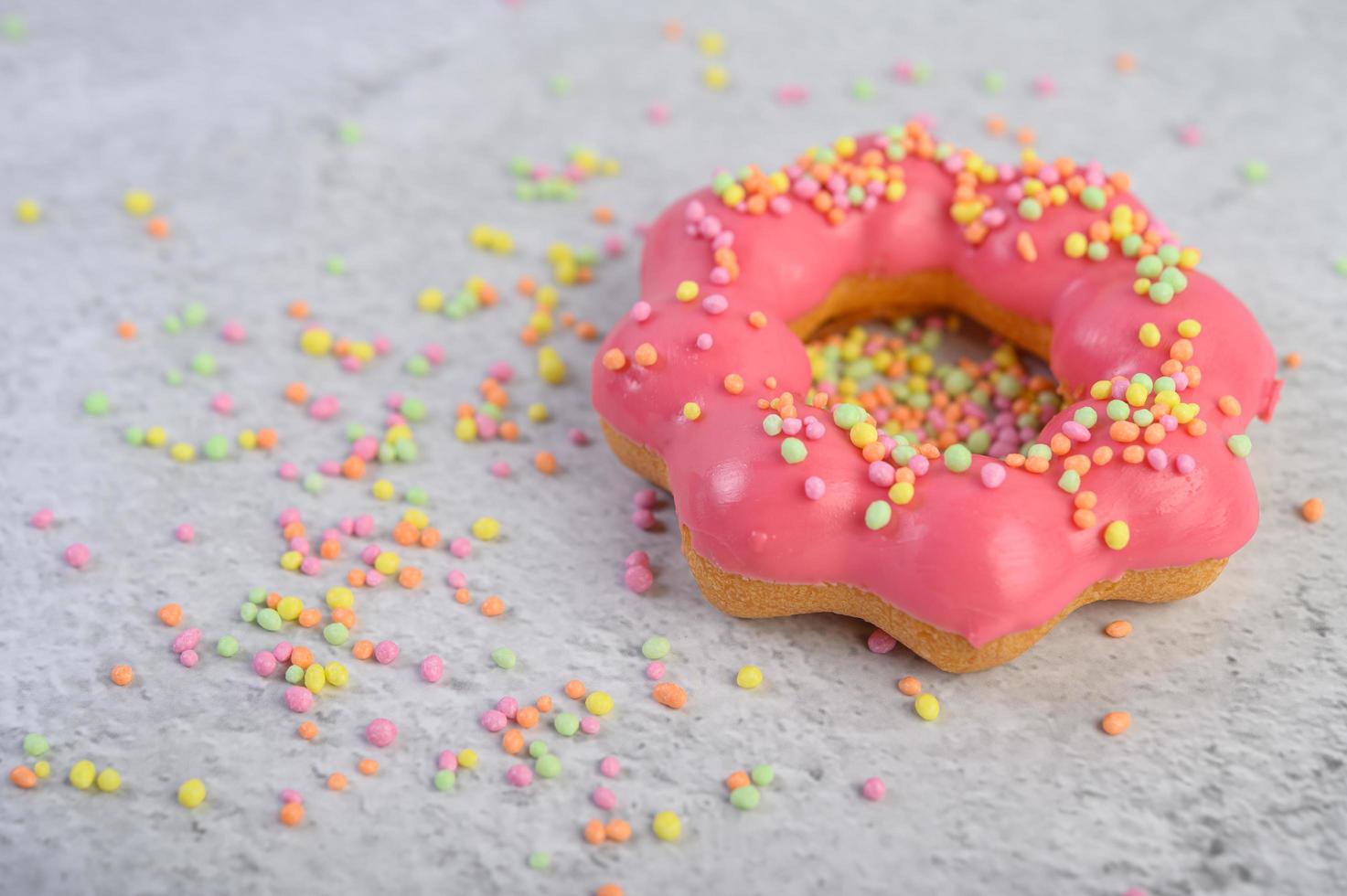 Strawberry donut decorated with icing and sprinkles photo