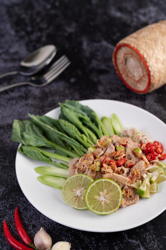 Spicy lime pork salad on a bed of greens photo