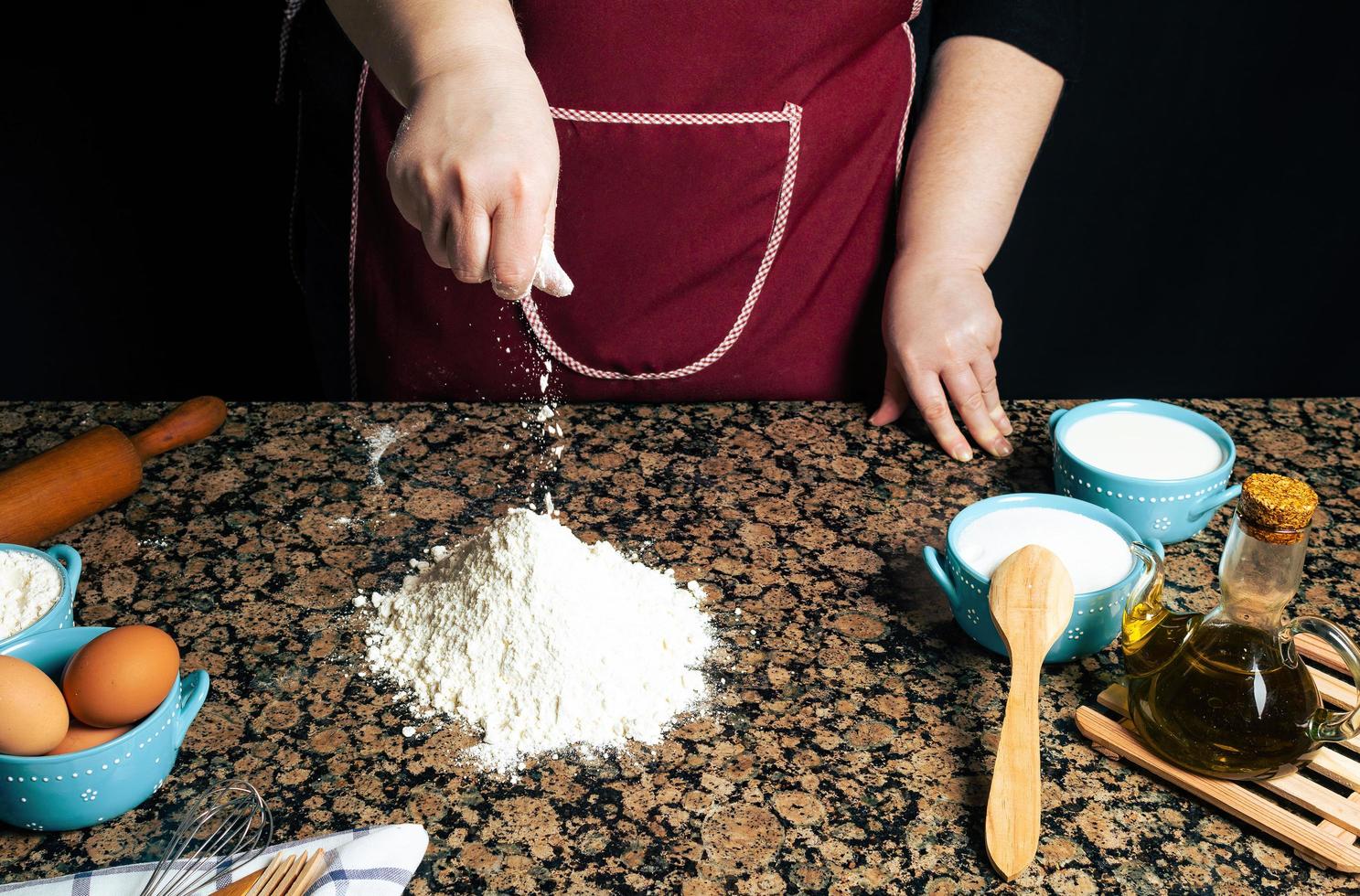 Person placing flour on a counter photo