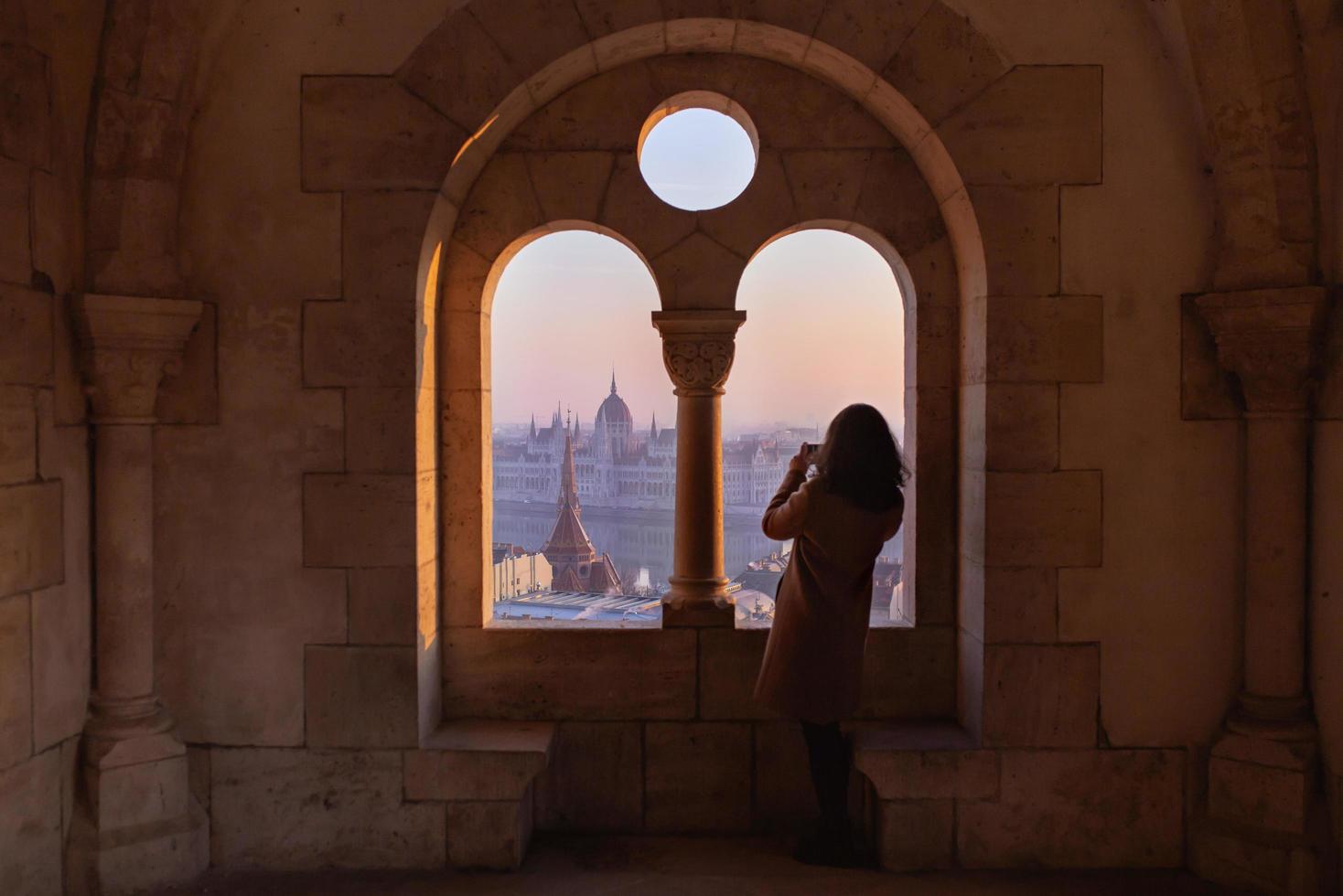 mujer de pie en una ventana en budapest foto