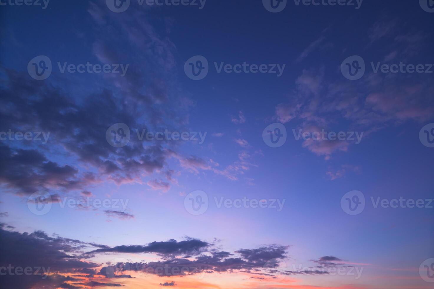 A sunset over the ocean with clouds and a boat photo