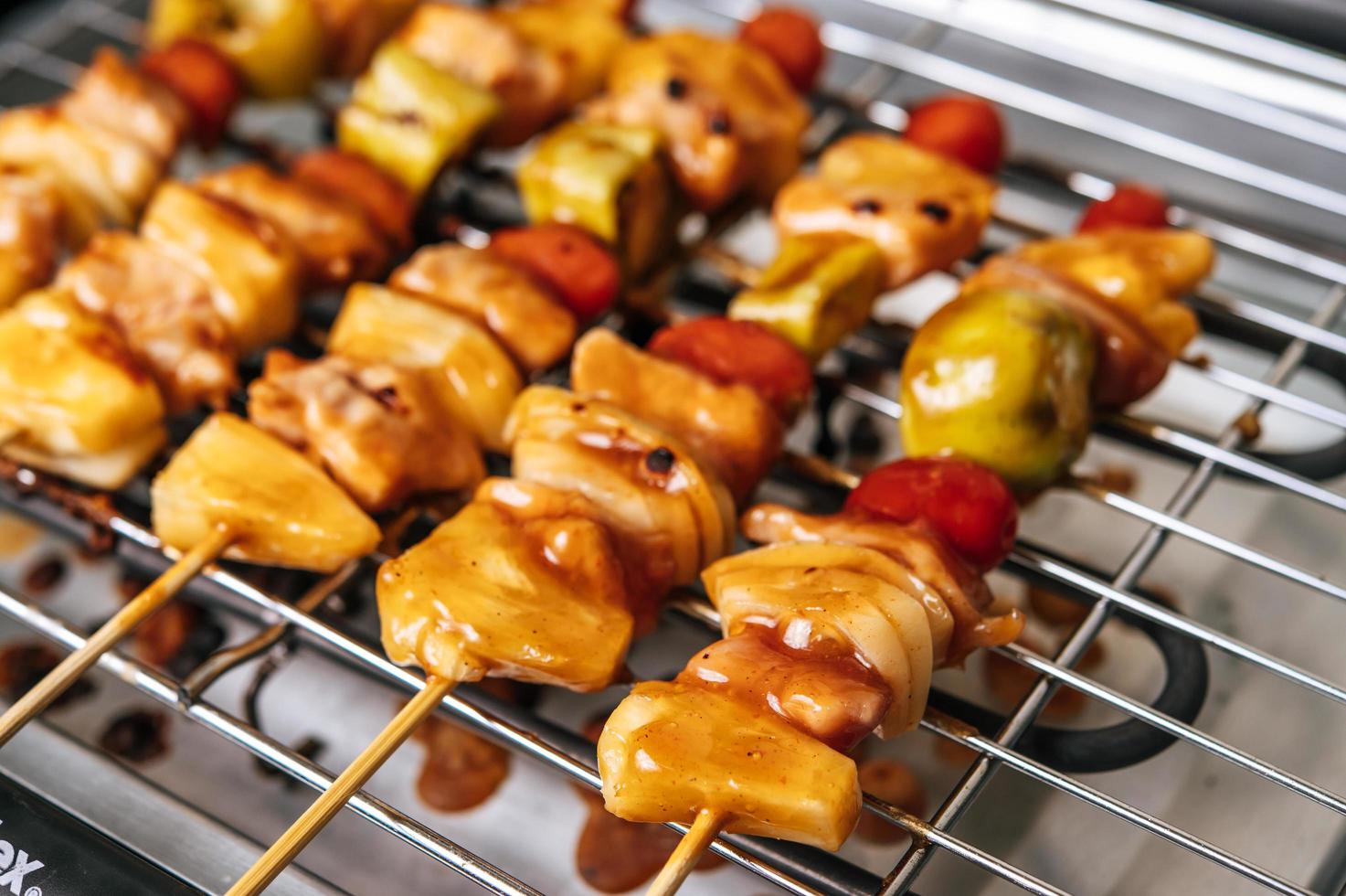 BBQ grill with a variety of meats, tomato and peppers photo