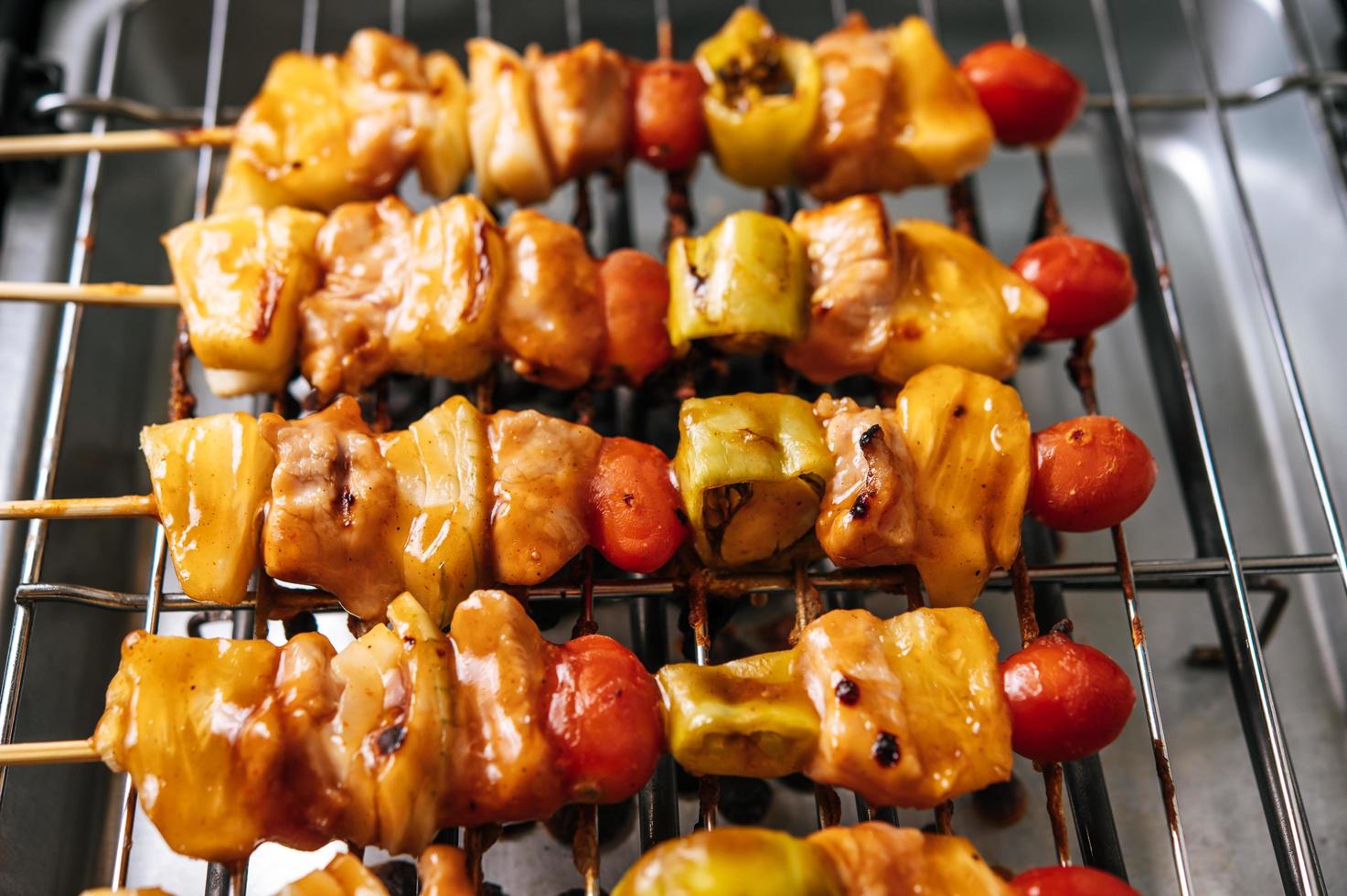 parrilla de barbacoa con variedad de carnes, tomate y pimientos foto