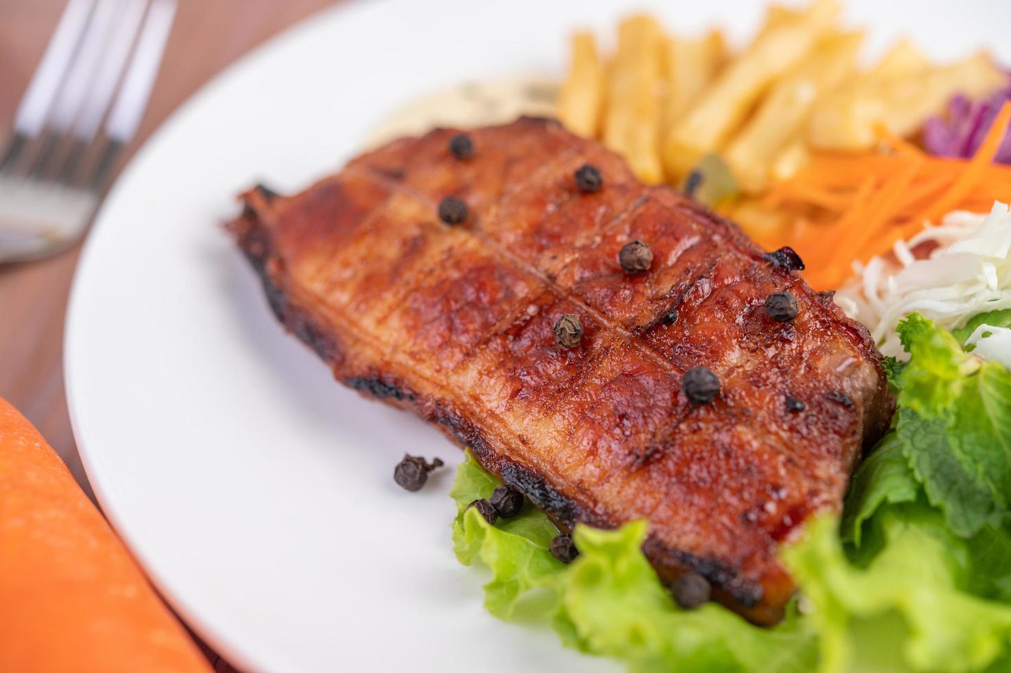 Filete de pescado con patatas fritas, frutas y verduras. foto