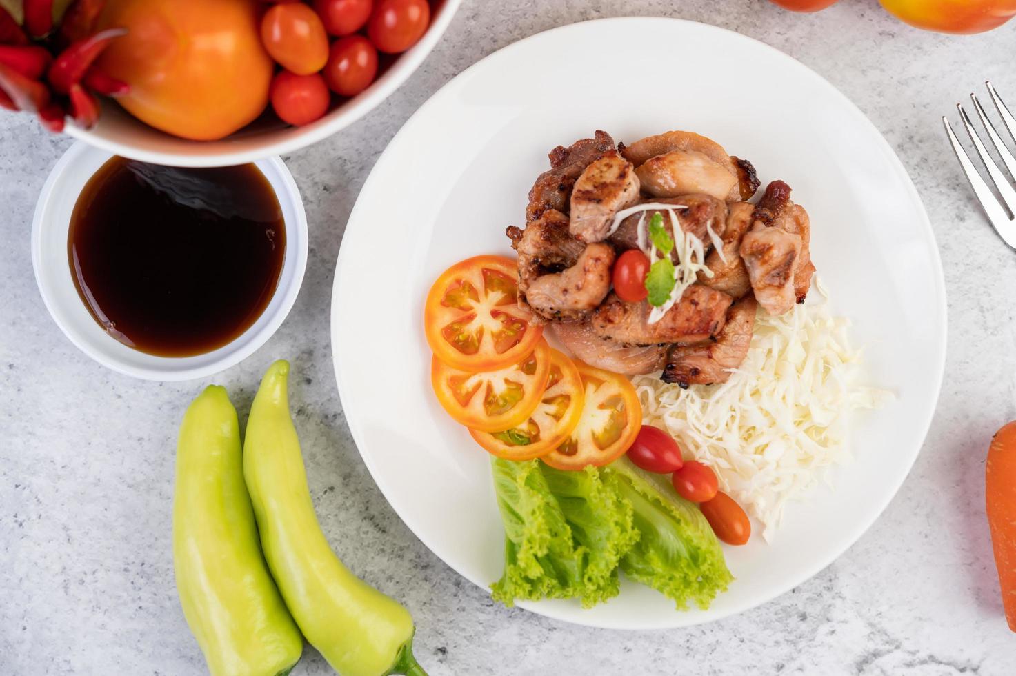 Grilled pork cutlet with tomatoes and salad photo