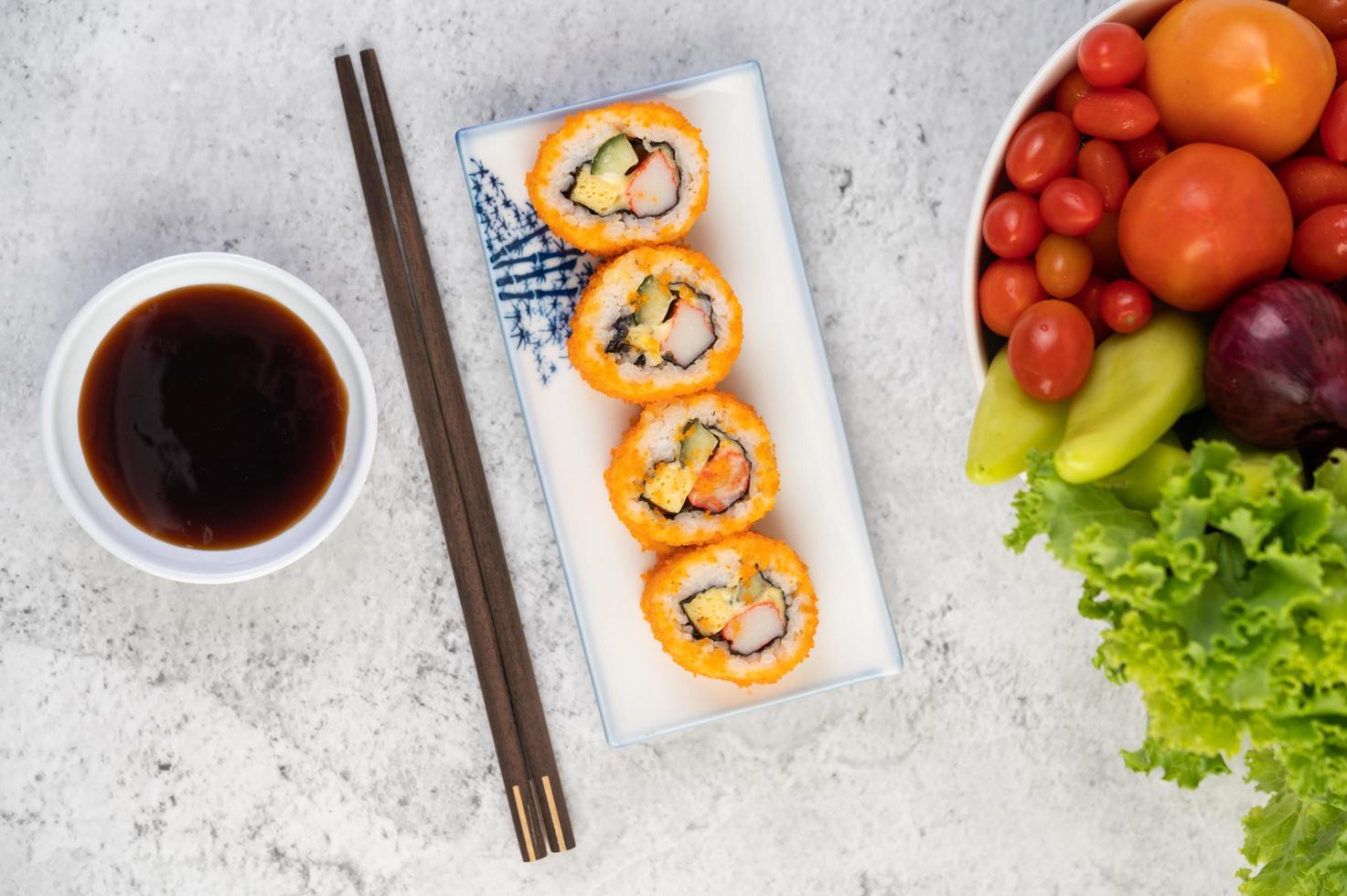 Plated sushi with sauce and chopsticks photo