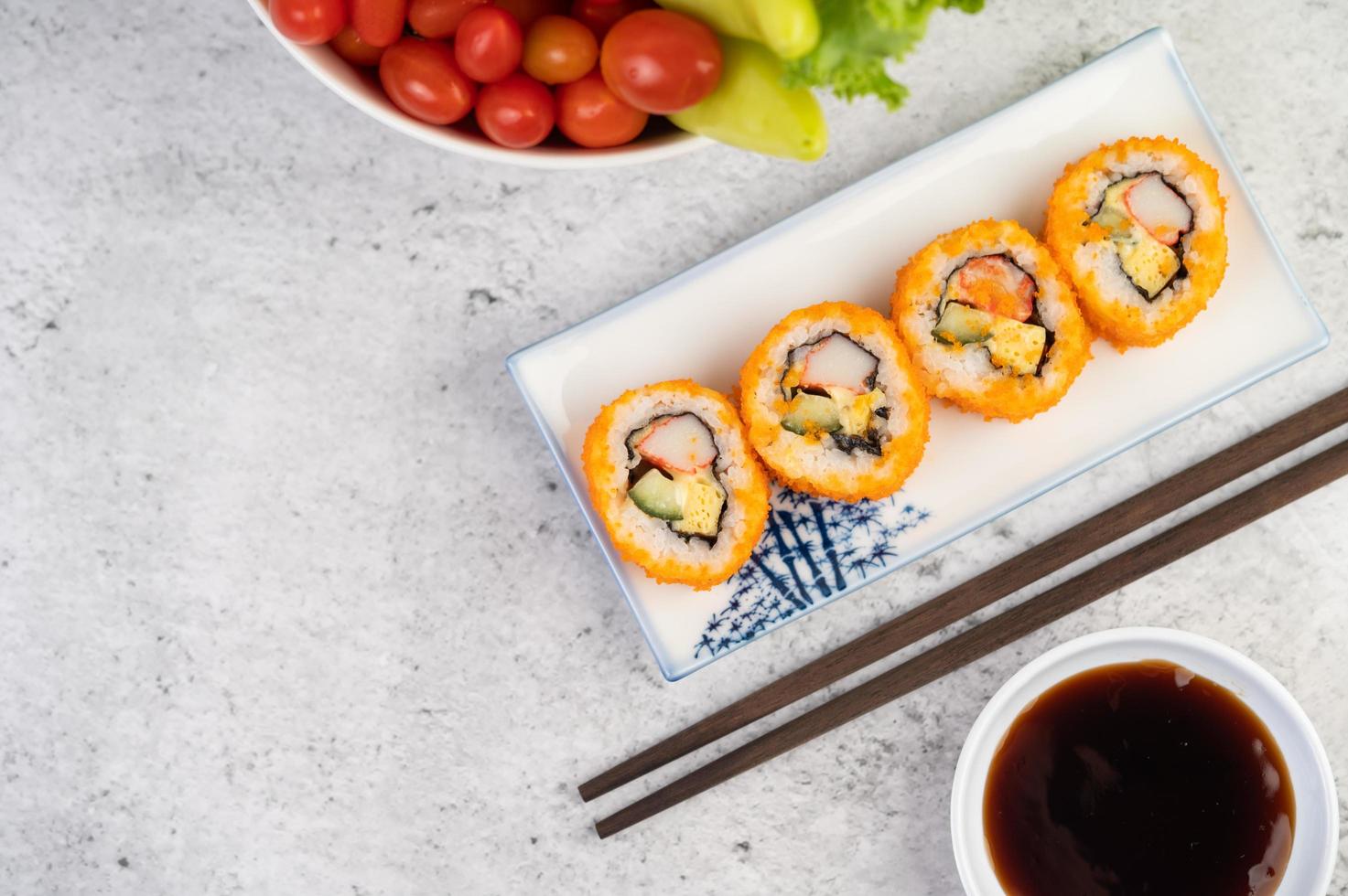 Plated sushi with sauce and chopsticks photo