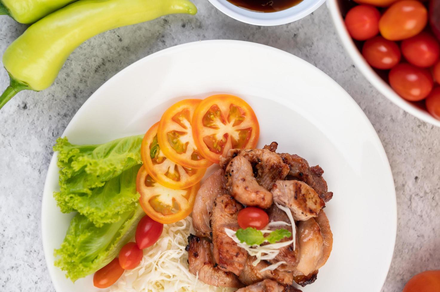 Grilled pork cutlet with tomatoes and salad photo