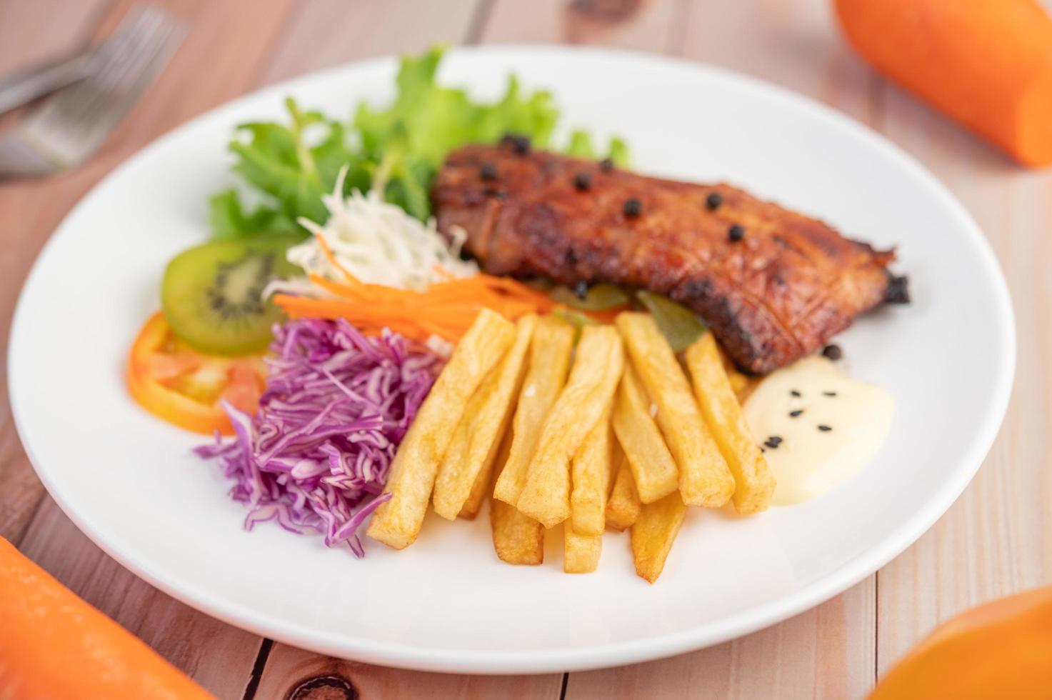 Fish steak with french fries, fruit and vegetables photo