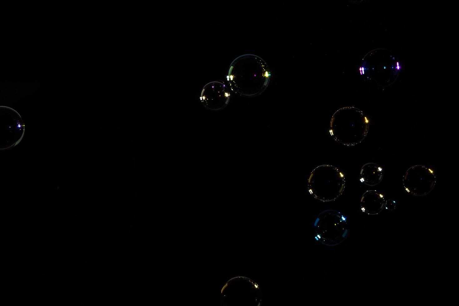 Soap bubbles floating in the air on a black background photo