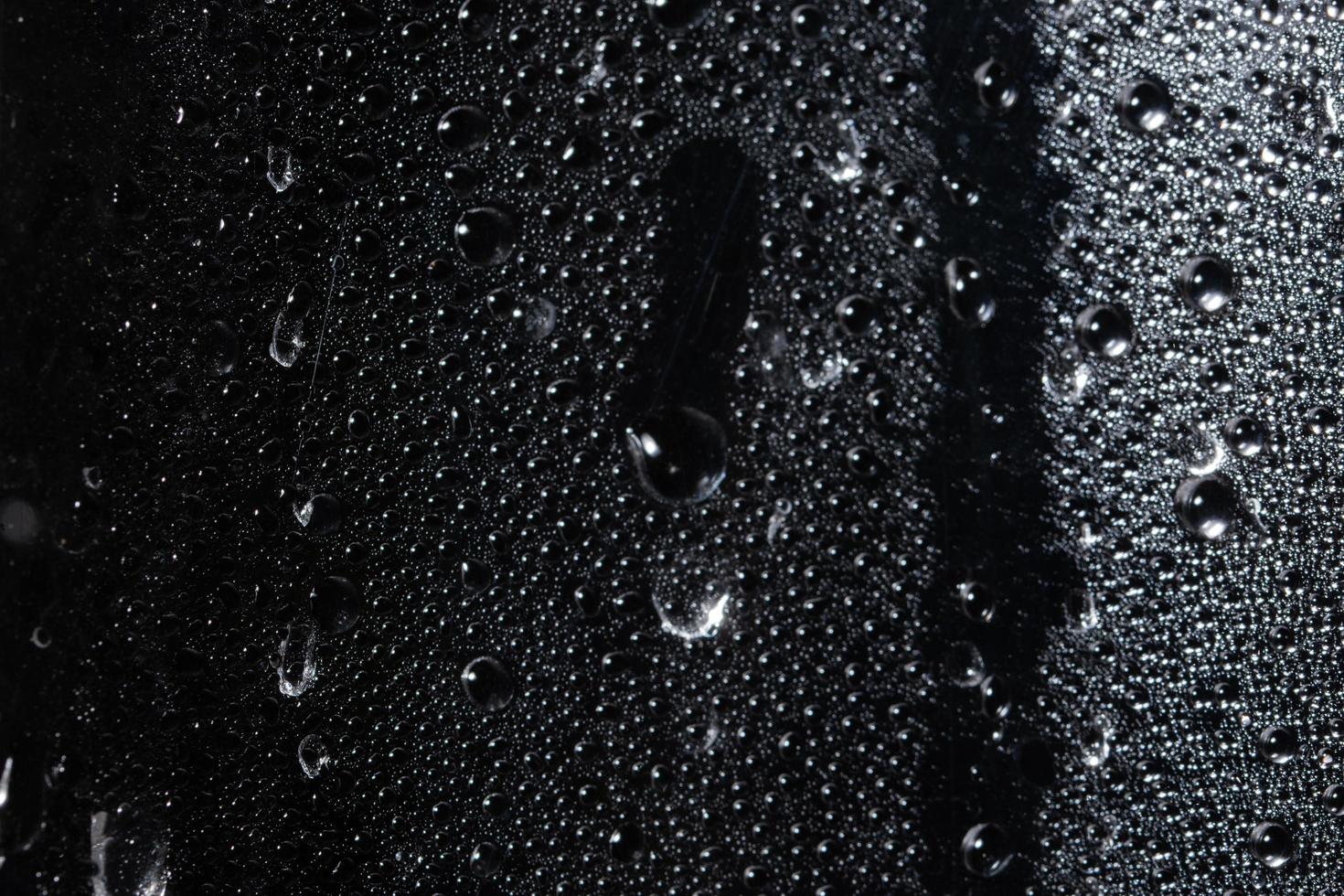 Droplets on transparent plastic sheet, black background photo