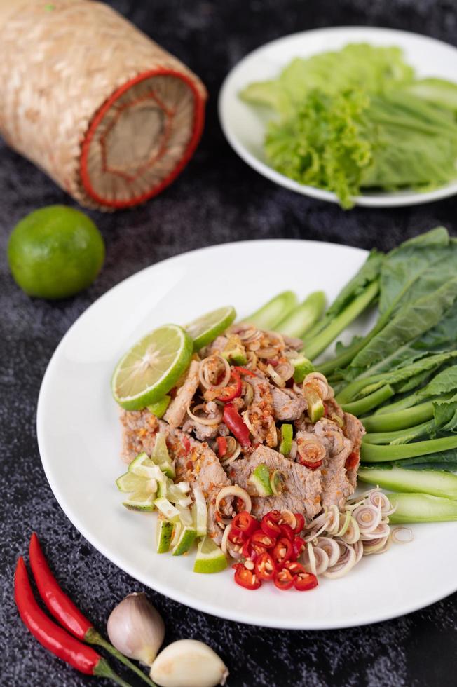 Spicy lime pork salad on a bed of greens photo