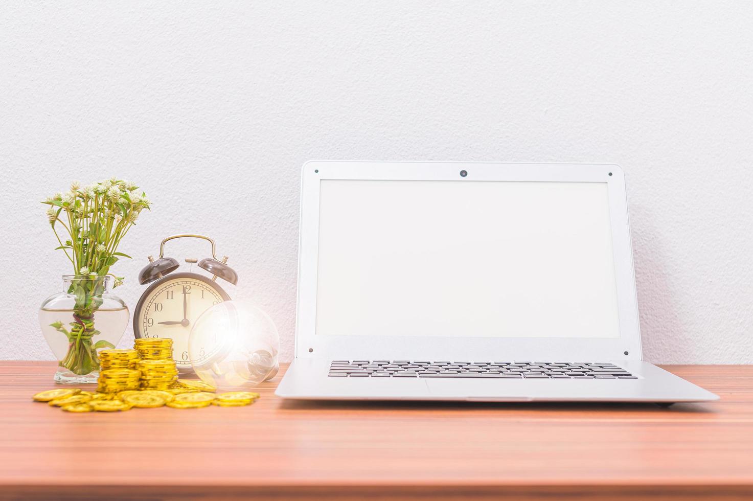 Laptop and coins on the desk photo