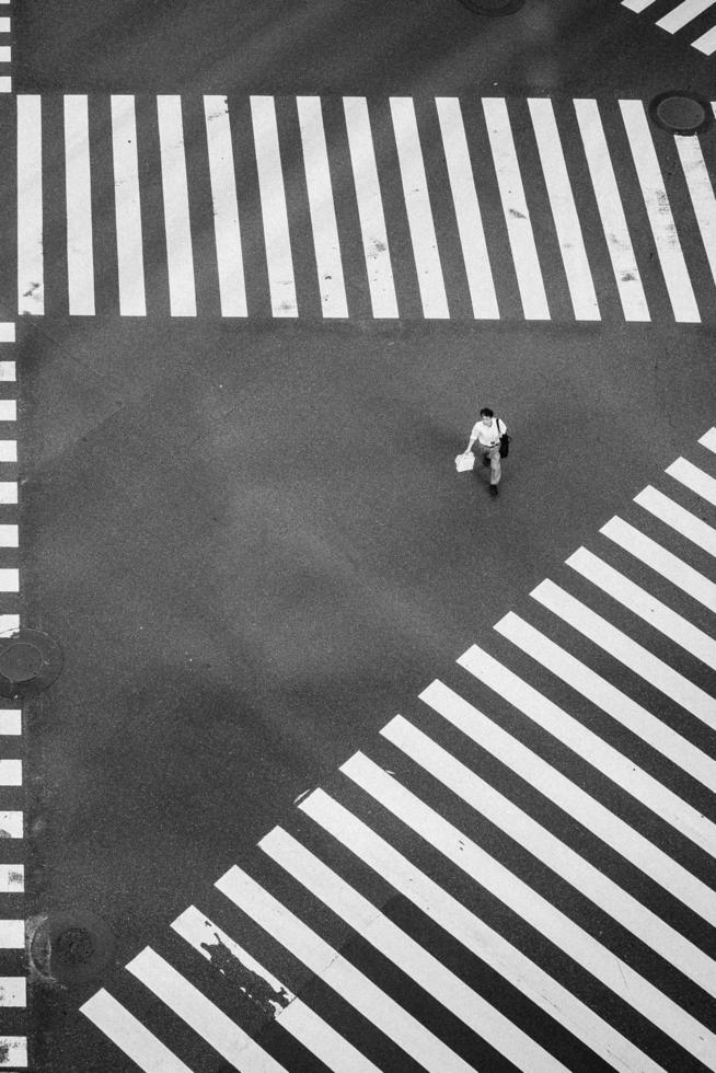 man walking at the center of crisscrossing pedestrian lanes photo