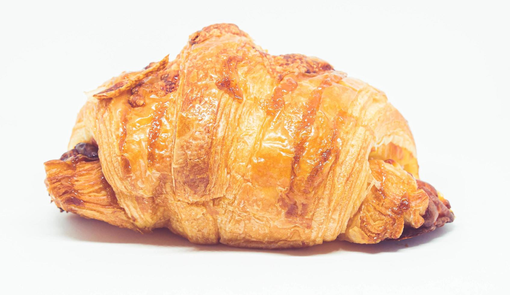Rollo de croissant sobre un fondo blanco. foto
