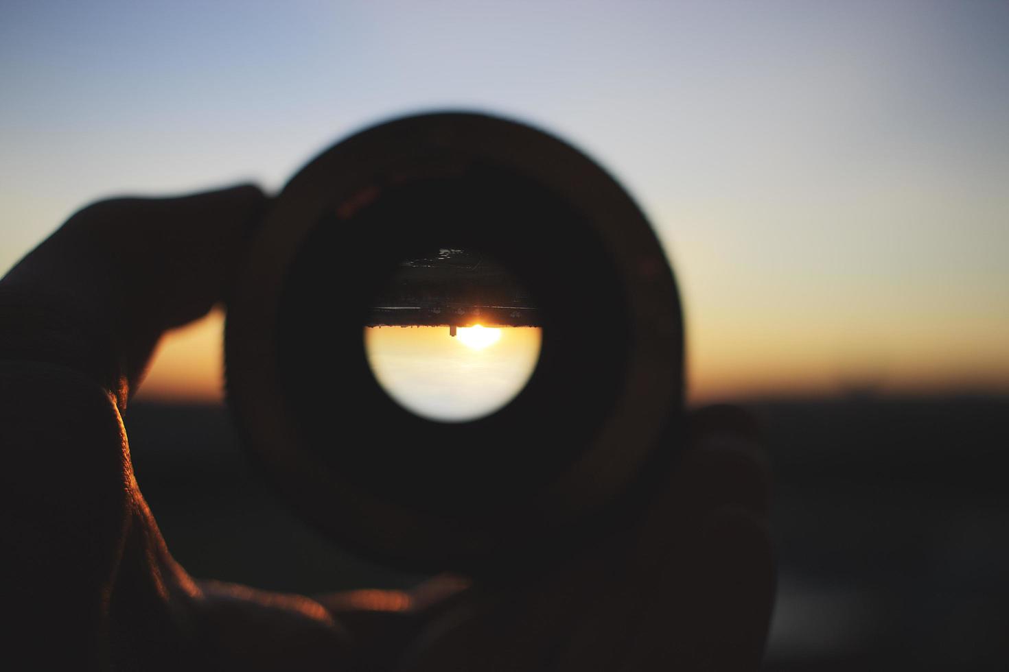 Person holding round camera lens photo