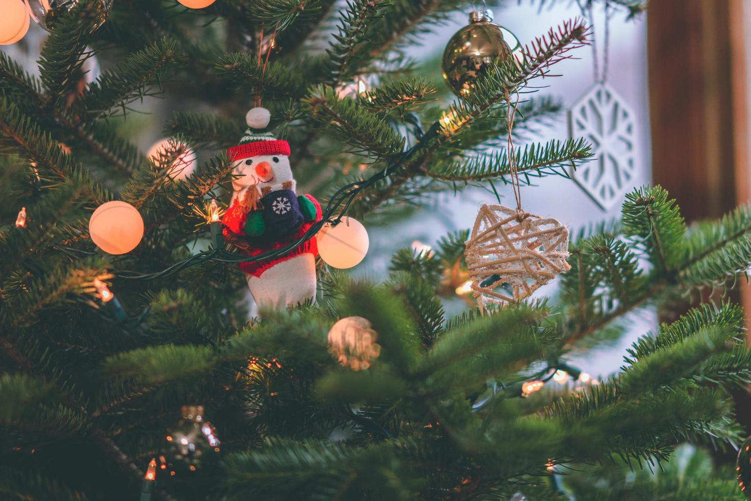 decoración de muñeco de nieve en un árbol de navidad foto