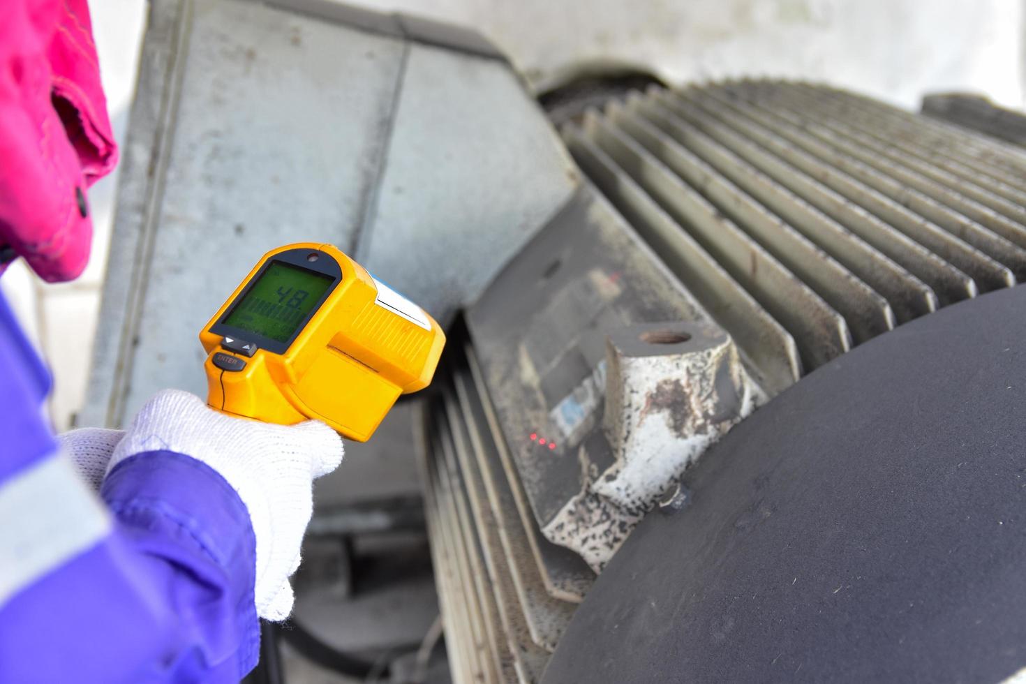 los trabajadores miden la temperatura del motor foto